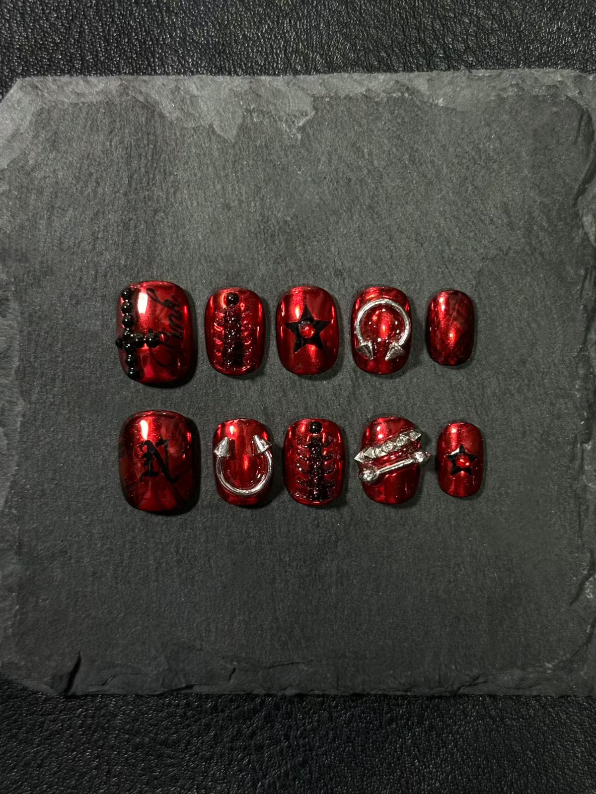 Red press-on nails with studs, inspired by "Nine Vicious"